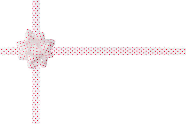 Decorative white with red dots tied fluffy bow and ribbon for gift box packing isolated on white background. Paper ribbon and festive tied bow for holiday present pack. Ribbon and fluffy bow for design.
