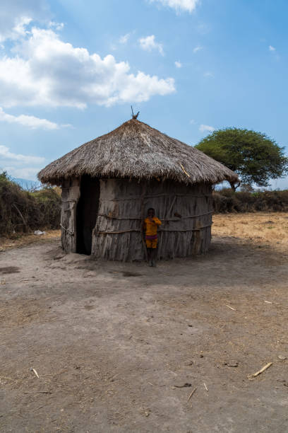 Jinka, Ethiopia - August 14, 2010: Three children, a girl and two boys, sit outside a home in the southeastern town of Jinka. Jinka is known for its large market, and as the gateway to the Omo Valley.