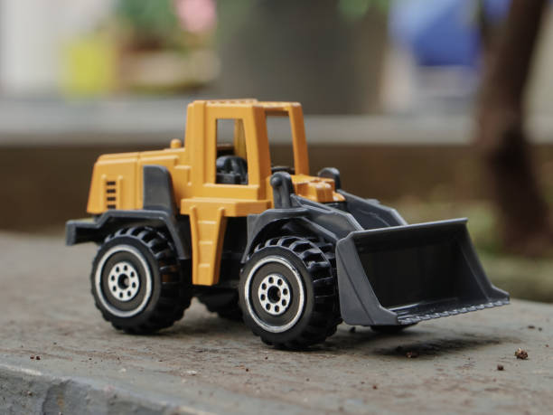 istock Yellow wheel loader or bulldozer toy outdoor with blurred background. construction image concept. side view photograph 2187677205
