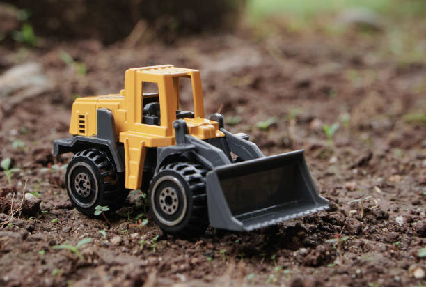 istock Yellow wheel loader or tractor toy on soil or ground background. construction image concept with heavy equipment. 2187677207