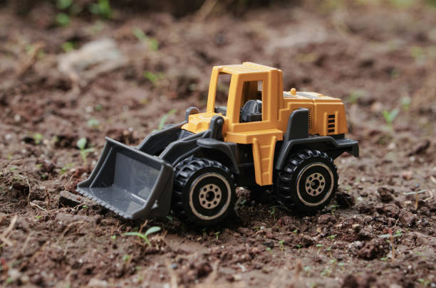 istock Yellow wheel loader or tractor toy on soil or ground background. construction image concept with heavy equipment. 2187677222