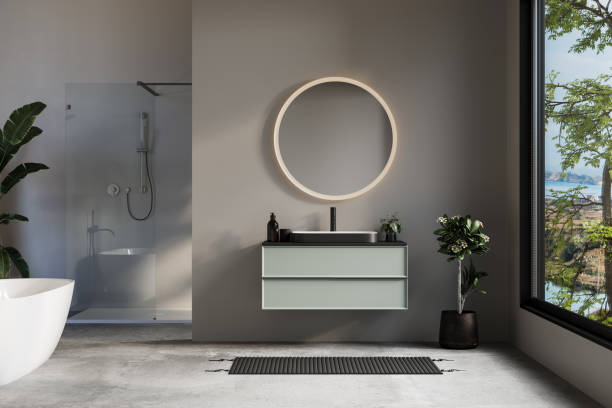 istock Minimalist bathroom with a freestanding bathtub, round mirror, floating vanity, and walk-in shower, complemented by natural light and greenery. 2187677276