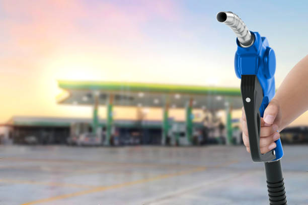 istock Holding a fuel nozzle against with gas station blurred background 2187681568