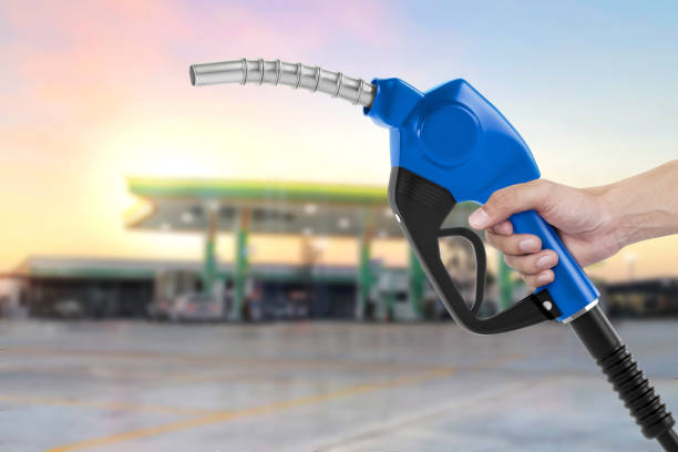 istock Holding a fuel nozzle against with gas station blurred background 2187681634