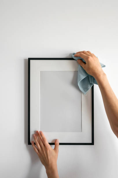 istock Cleaning a blank picture frame on a modern home wall in daylight hours 2187684479