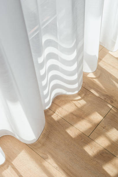 istock Bright sunlight filters through sheer curtains in a modern home interior 2187684504