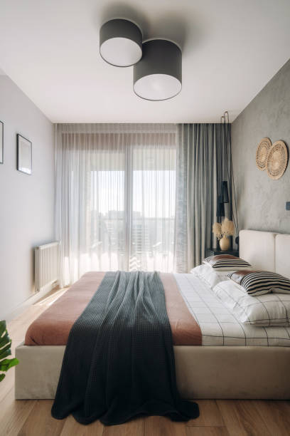 istock Modern bedroom with stylish decor and large windows showcasing city views 2187684523