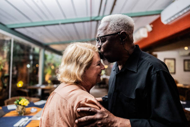 istock Husband kissing his wife's forehead at a restaurant 2187686204
