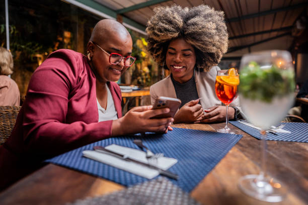 istock Young friends using the mobile phone at a restaurant 2187686675