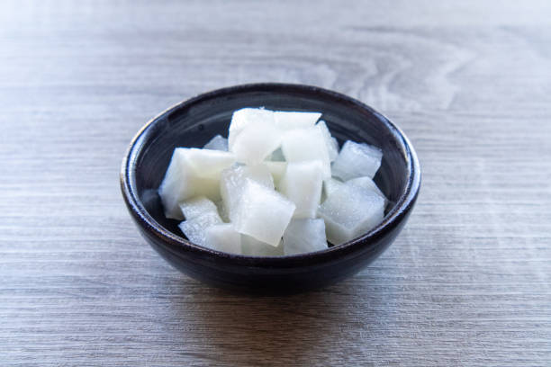 istock White pickled radishes on a black plate on a wooden table 2187689441