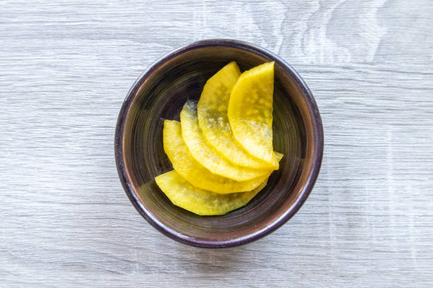 Danmuji (Korean pickled radish) in a black plate on a wooden table