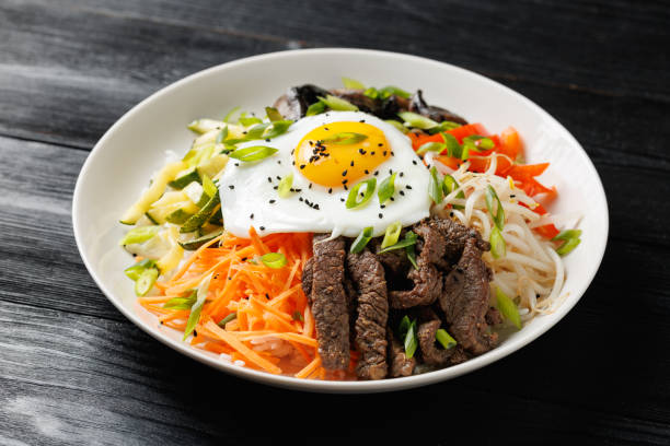 istock Traditional Korean dish Bibimbap with rice, vegetables beef and egg in a white plate 2187691153