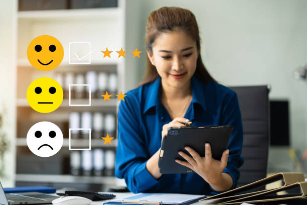 istock Woman holding a digital tablet with checkboxes rating smiley faces excellent for Satisfaction Survey, Happy Client Customer Experience concept. 2187698001