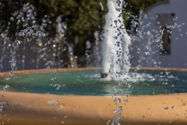 istock Water drops splashing from a fountain in a park 2187699409