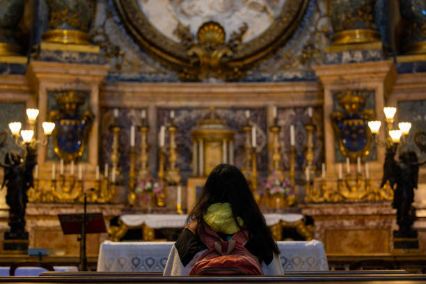 istock A woman praying in a church 2187701908