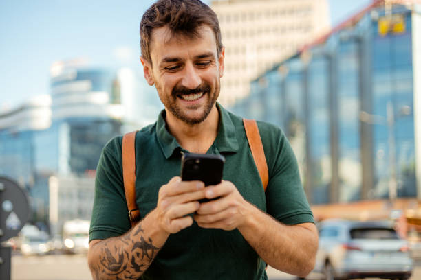 istock Urban Connection: Smiling Millennial Using Phone in Vibrant City 2187708818