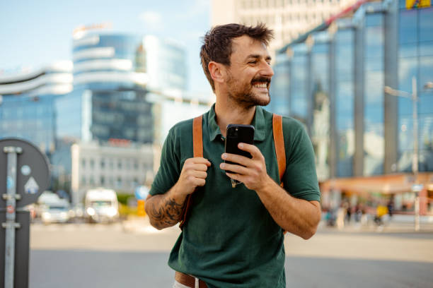istock Urban Connection: Smiling Millennial Using Phone in Vibrant City 2187709327