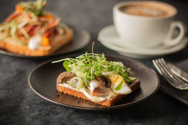 istock A close-up of a rustic toast topped with herring, boiled egg, greens 2187713354