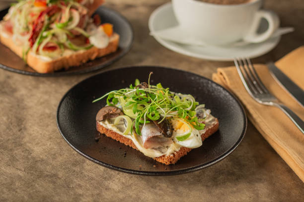 istock A close-up of a rustic toast topped with herring, boiled egg, greens 2187713411