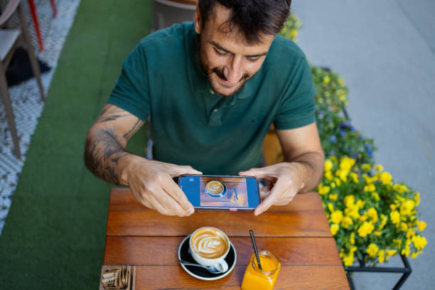 Savoring the Moment: Man in Cozy Coffee Shop Capturing His Cappuccino