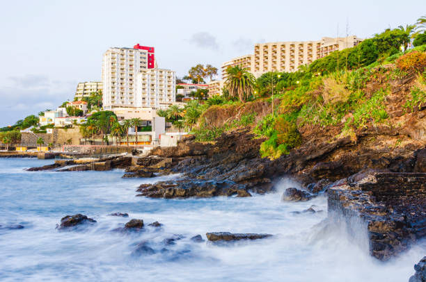 istock Waves on coastline in front of buildings 2187714689