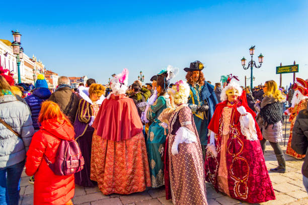 Venice,Italy-February 8th 2015:Masked people wearing spectacular colorful costumes, disguised persons at Saint Mark square during the Venice Carnival Opening Ceremony