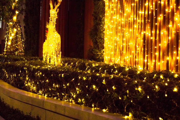 Golden illuminated xmas lights and decor on driveway to apartment tower in Bangkok
