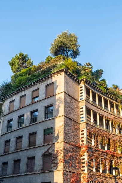 istock Building with green rooftop garden, featuring trees and greenery cascading over the structure, blending architecture with nature, Milan, Italy. Eco friendly urban environment. Sustainable architecture 2187727242