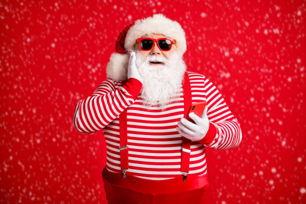istock Portrait of his he nice handsome attractive cheerful amazed delighted bearded fat Santa using device app 5g browsing shopping isolated on bright vivid shine vibrant red color background 2187729552