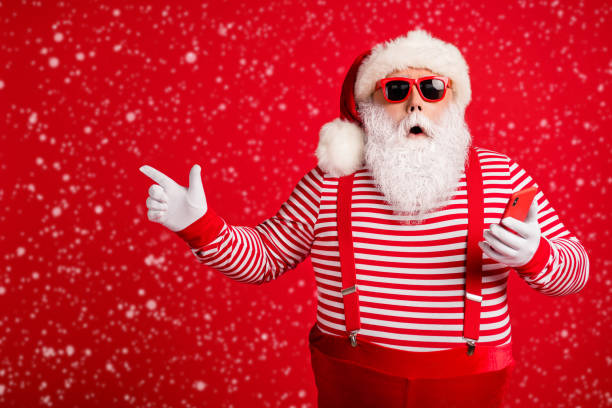 istock Portrait of his he nice handsome amazed bearded fat overweight Santa using gadget demonstrating copy space bargain December novelty isolated bright vivid shine vibrant red color background 2187729584