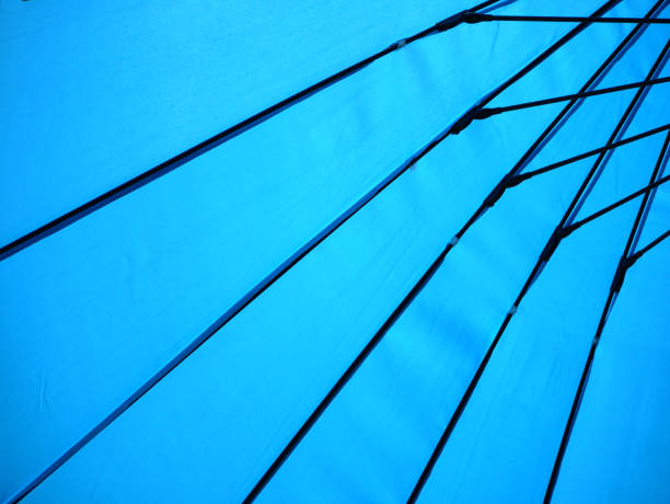 below a bright blue umbrella during sunshine in sunny weather