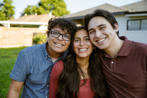 istock Multigeneration siblings or friends looking at camera in the front yard and smiling 2187734604