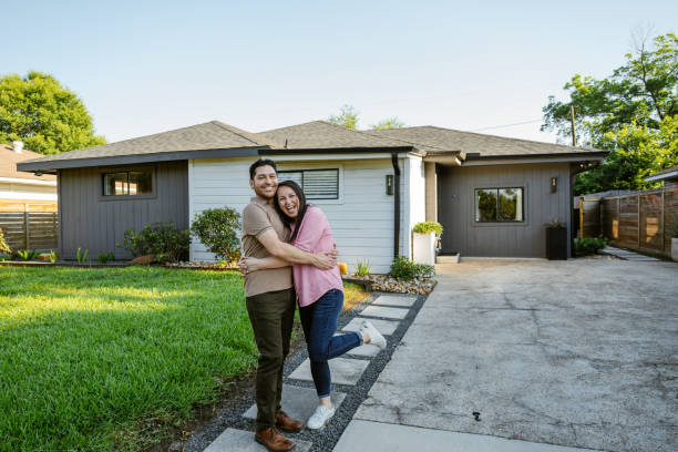 Family proudly posing in front of newly bought house