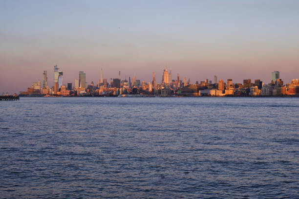 A photo of New York City taken form New Jersey on sunset with the Hutson river on the foreground