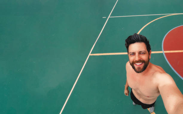 istock Mid adult man holding camera and smiling while practicing sport 2187739561