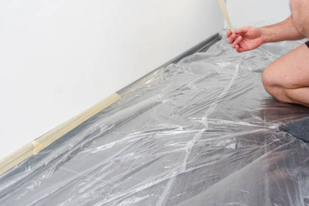istock Man is painting a wall with a plastic sheet on the floor 2187739850