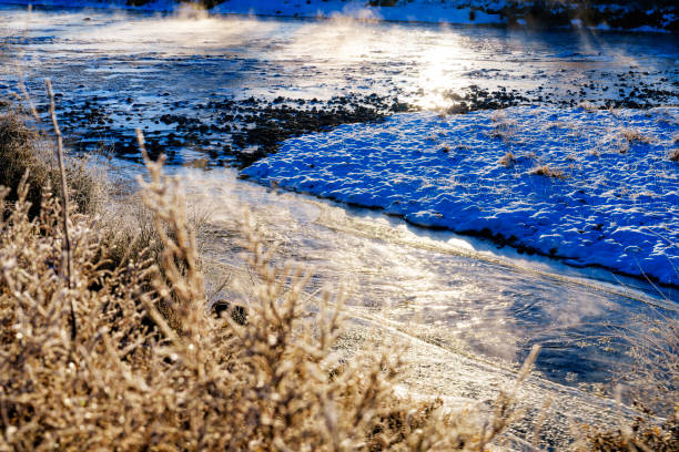 Enchanting winter landscape with sun rays over the snowy and frosty grass, on a meadow, surrounded by forest, near Garmisch-Partenkirchen, Germany.