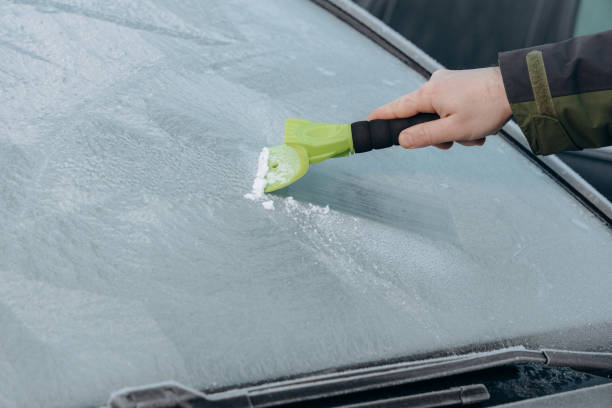 istock clearing snow and ice from the car. 2187743596