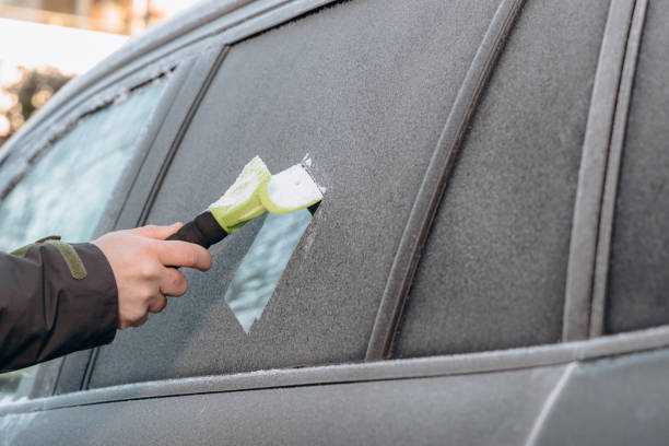 istock clearing snow and ice from the car. 2187743803