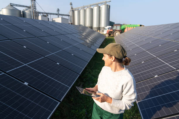istock Female farmer with digital tablet on a modern farm using solar panels. Agricultural silos in the background. 2187746459