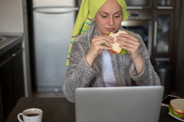 istock Freelancer works from home in robe, types on laptop, drinks coffee, enjoys domestic atmosphere, surfs web, reads skincare advice 2187748525