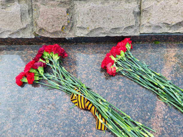 istock Two bouquets of red carnations lie on a marble slab. 2187751843