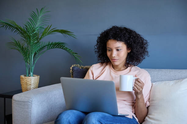 istock Latin woman working remotely from home office using laptop and drinking coffee 2187751850