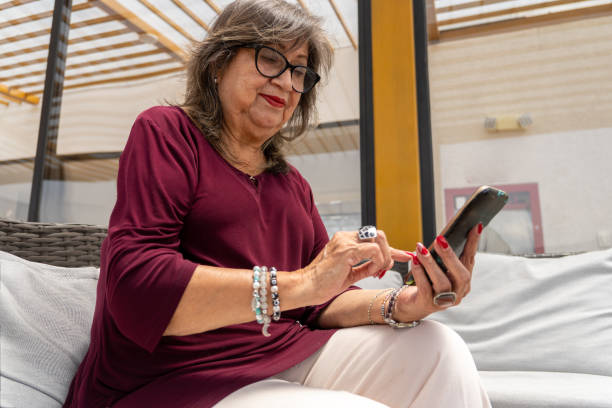 istock Senior mature woman looking at her cell phone and texting 2187753006