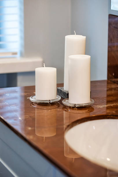 istock White Pillar Candles on Polished Brown Marble Countertop 2187759088