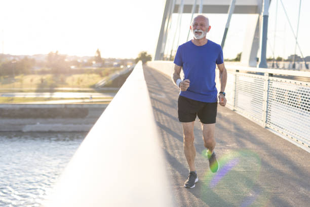 istock Elderly man jogging on bridge during sunset in athletic attire. 2187763399