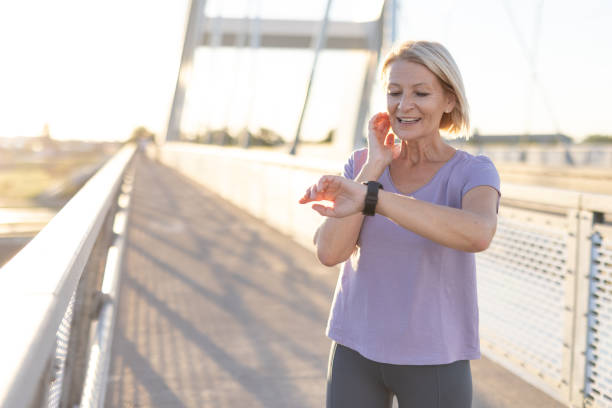 istock Woman checking smartwatch on bridge during workout under sunlight 2187763400
