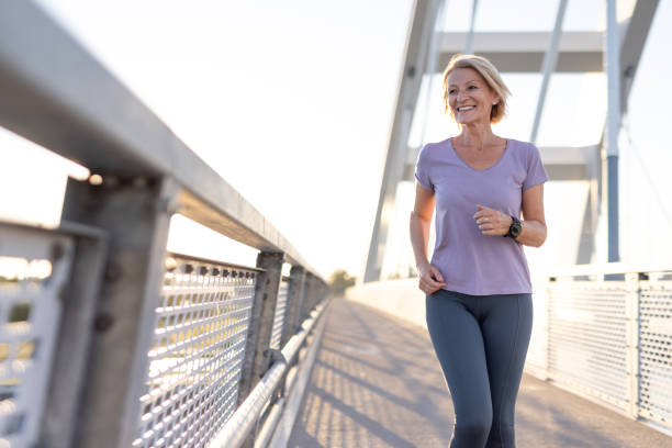 istock Woman smiling while jogging on a bridge on a sunny morning. 2187763412