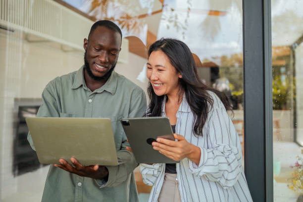 Professional Interaction Between Black Man and Asian Woman with Tech Devices