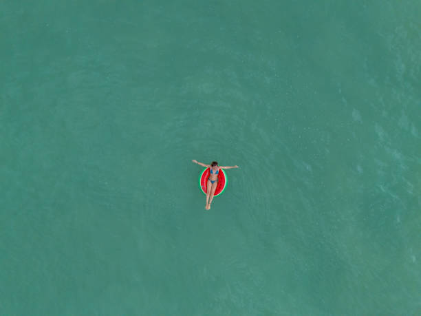 istock Woman Relaxing on Inflatable Ring in Turquoise Ocean 2187765828